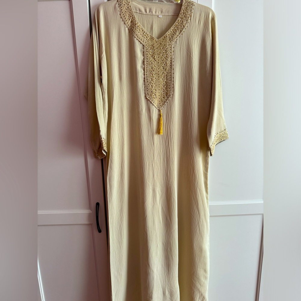Abaya with patterns on the chest and a gold line at the bottom
